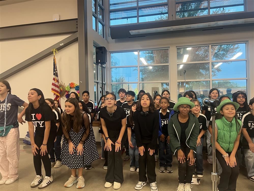  Image is a student choir, where the students are dressed as different characters from Broadway.